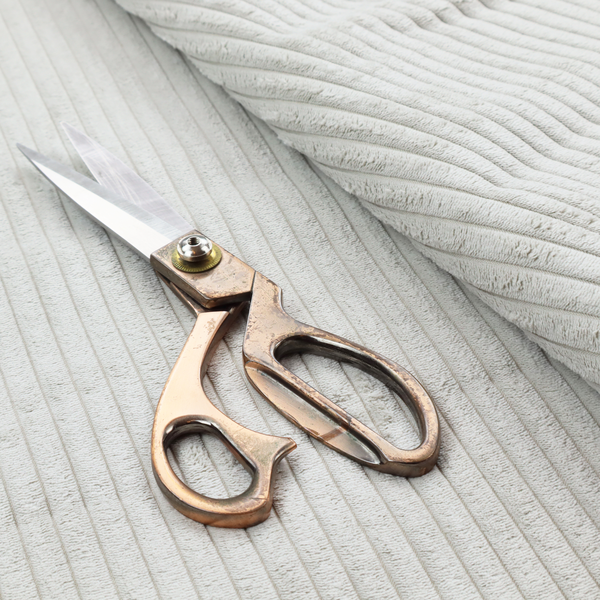 This fabric is a light grey corduroy featuring a consistent vertical ribbed texture.