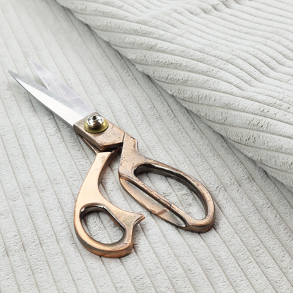 This fabric is a light grey corduroy featuring a consistent vertical ribbed texture.