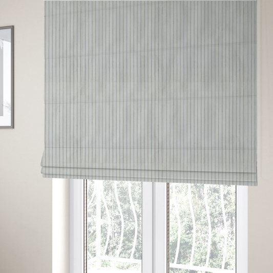 The fabric used to create these Roman blinds is a light grey corduroy featuring a consistent vertical ribbed texture.