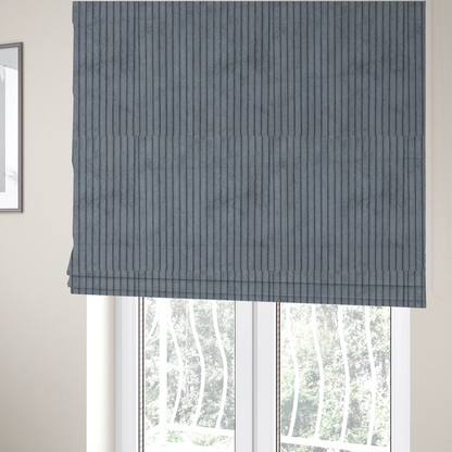 The fabric used to create these Roman blinds is a medium-to-dark grey corduroy featuring a consistent vertical ribbed texture.