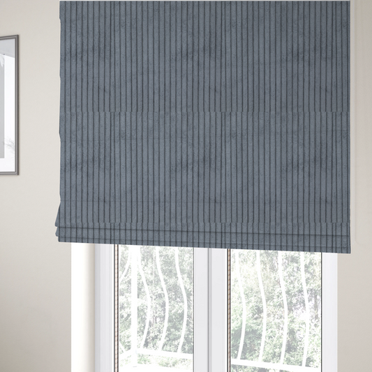 The fabric used to create these Roman blinds is a medium-to-dark grey corduroy featuring a consistent vertical ribbed texture.