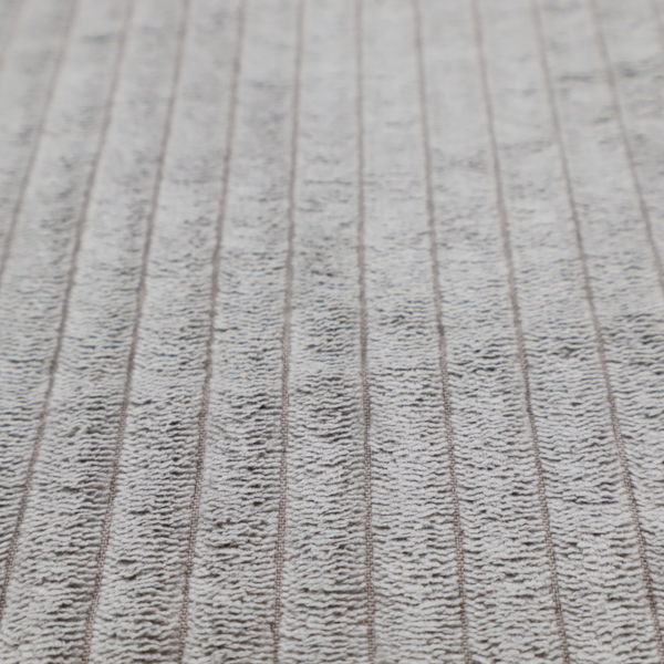 This fabric is a cool-toned, light grey or silver-grey corduroy featuring a consistent vertical ribbed texture.