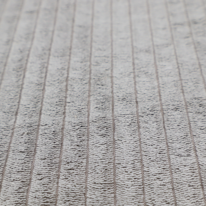 This fabric is a cool-toned, light grey or silver-grey corduroy featuring a consistent vertical ribbed texture.