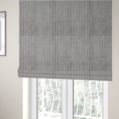 The fabric used to create these Roman blinds is a cool-toned, light grey or silver-grey corduroy featuring a consistent vertical ribbed texture.