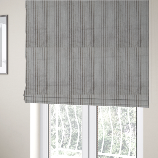 The fabric used to create these Roman blinds is a cool-toned, light grey or silver-grey corduroy featuring a consistent vertical ribbed texture.