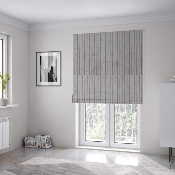The fabric used to create these Roman blinds is a cool-toned, light grey or silver-grey corduroy featuring a consistent vertical ribbed texture.