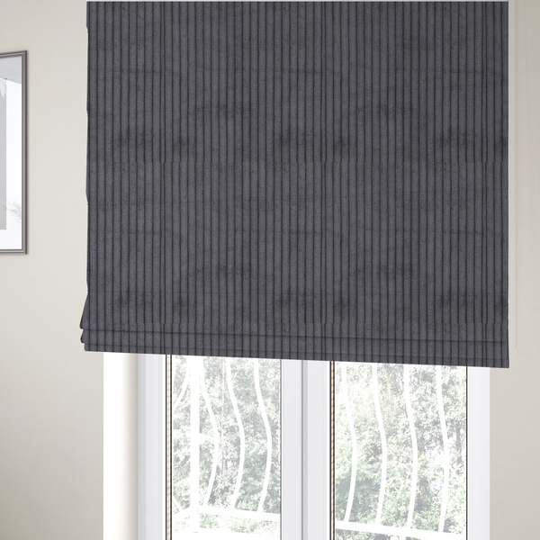 The fabric used to create these Roman blinds is a dark, cool-toned charcoal or slate-grey corduroy featuring a consistent vertical ribbed texture.