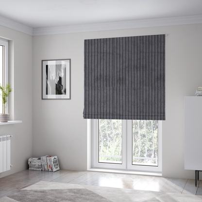 The fabric used to create these Roman blinds is a dark, cool-toned charcoal or slate-grey corduroy featuring a consistent vertical ribbed texture.