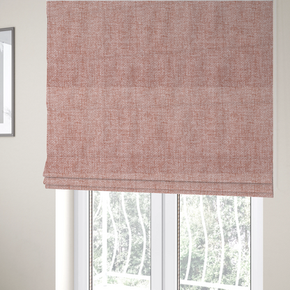 The fabric used to create these Roman blinds is a tightly woven fabric in a dusty rose or muted terracotta colour, featuring a textured basket-weave pattern.
