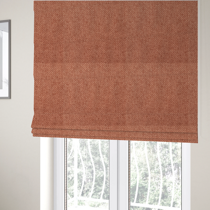 The fabric used to create these Roman blinds is a tightly woven fabric in a warm, muted copper or terracotta shade, featuring a distinct, structured basket-weave pattern.