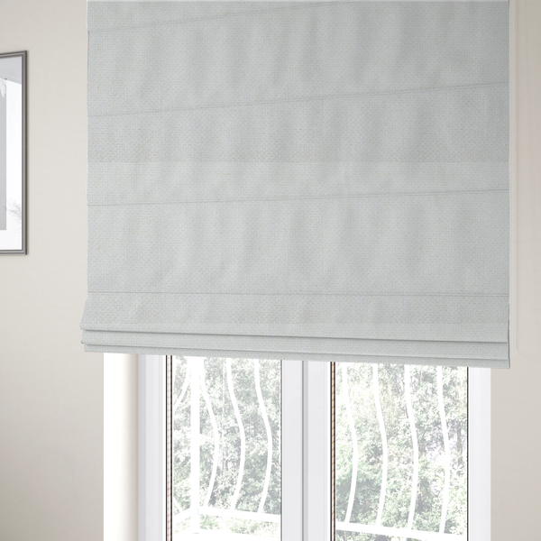 The fabric used to create these Roman blinds is a tightly woven fabric in a clean, crisp off-white or light cream shade, featuring a distinct, structured basket-weave pattern.