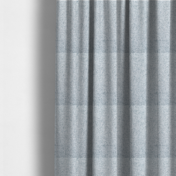 The fabric used to create these made-to-measure curtains is a tightly woven fabric in a soft, cool-toned sky blue and white blend, featuring a distinct, structured basket-weave pattern.