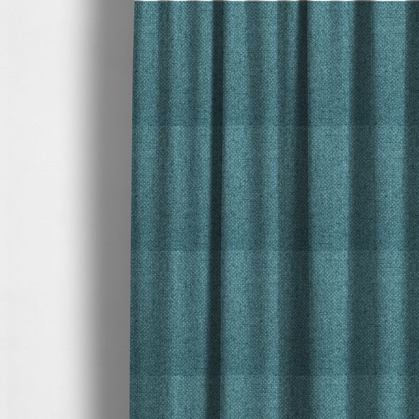 The fabric used to create these made-to-measure curtains is a tightly woven fabric in a deep, cool-toned teal or seafoam blue, featuring a distinct, structured basket-weave pattern.