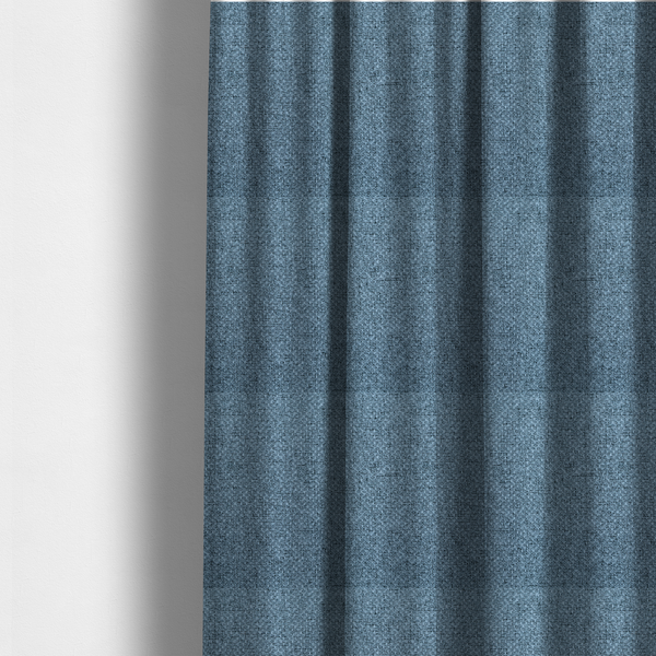 The fabric used to create these made-to-measure curtains is a tightly woven fabric in a cool, muted slate blue, featuring a distinct, structured basket-weave pattern.