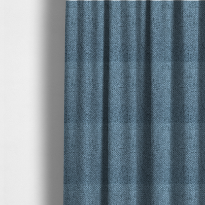The fabric used to create these made-to-measure curtains is a tightly woven fabric in a cool, muted slate blue, featuring a distinct, structured basket-weave pattern.