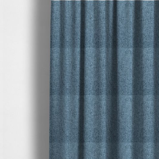 The fabric used to create these made-to-measure curtains is a tightly woven fabric in a cool, muted slate blue, featuring a distinct, structured basket-weave pattern.