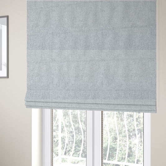 The fabric used to create these Roman blinds is a tightly woven fabric in a bright, airy, and cool-toned silvery white, featuring a distinct, structured basket-weave pattern.
