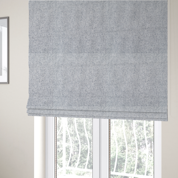 The fabric used to create these Roman blinds is a tightly woven fabric featuring a blend of white and cool-toned grey threads, creating a soft, light heathered effect with a distinct, structured basket-weave pattern.