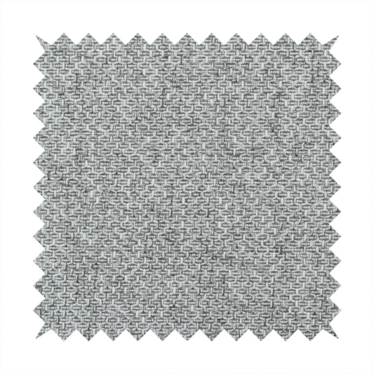 A tight, woven texture with a neutral, monochromatic colour palette. The surface consists of a blend of light grey, charcoal, and white yarns interlocked in a repeating, small-scale geometric pattern.