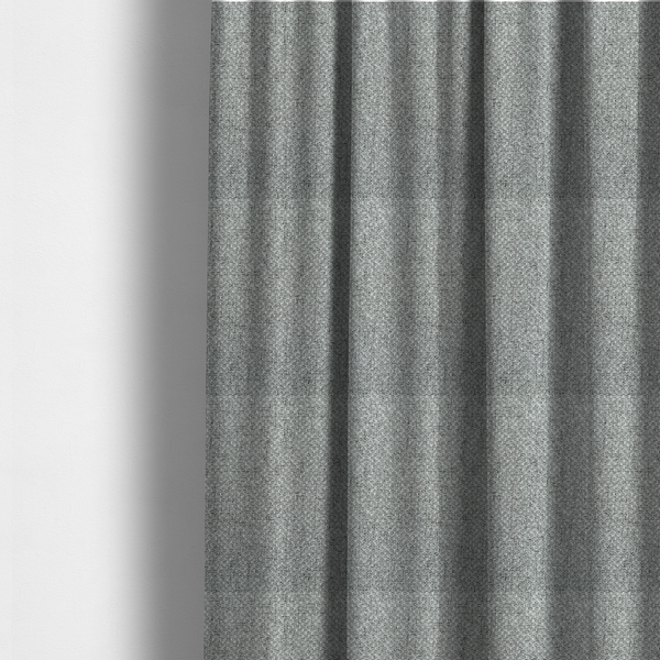 The fabric used to create these made-to-measure curtains is a tight, woven texture with a neutral, monochromatic colour palette. The surface consists of a blend of light grey, charcoal, and white yarns interlocked in a repeating, small-scale geometric pattern.