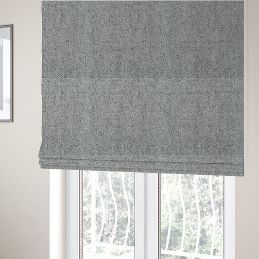 The fabric used to create these Roman blinds is a tight, woven texture with a neutral, monochromatic colour palette. The surface consists of a blend of light grey, charcoal, and white yarns interlocked in a repeating, small-scale geometric pattern.