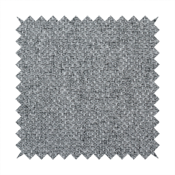 A durable, woven upholstery fabric featuring a monochromatic, heathered grey colour scheme. The weave is tight and consistent, characterized by an intricate, interlocking pattern of light, medium, and dark grey yarns that create a subtle, textured visual effect.