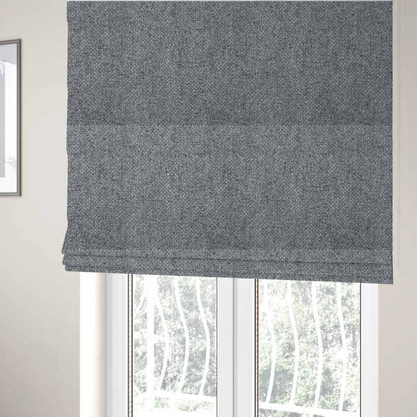 The fabric used to create these Roman blinds is a durable, woven upholstery fabric featuring a monochromatic, heathered grey colour scheme. The weave is tight and consistent, characterized by an intricate, interlocking pattern of light, medium, and dark grey yarns that create a subtle, textured visual effect.