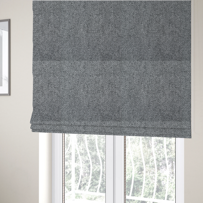 The fabric used to create these Roman blinds is a durable, woven upholstery fabric featuring a monochromatic, heathered grey colour scheme. The weave is tight and consistent, characterized by an intricate, interlocking pattern of light, medium, and dark grey yarns that create a subtle, textured visual effect.