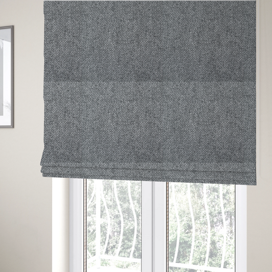 The fabric used to create these Roman blinds is a durable, woven upholstery fabric featuring a monochromatic, heathered grey colour scheme. The weave is tight and consistent, characterized by an intricate, interlocking pattern of light, medium, and dark grey yarns that create a subtle, textured visual effect.