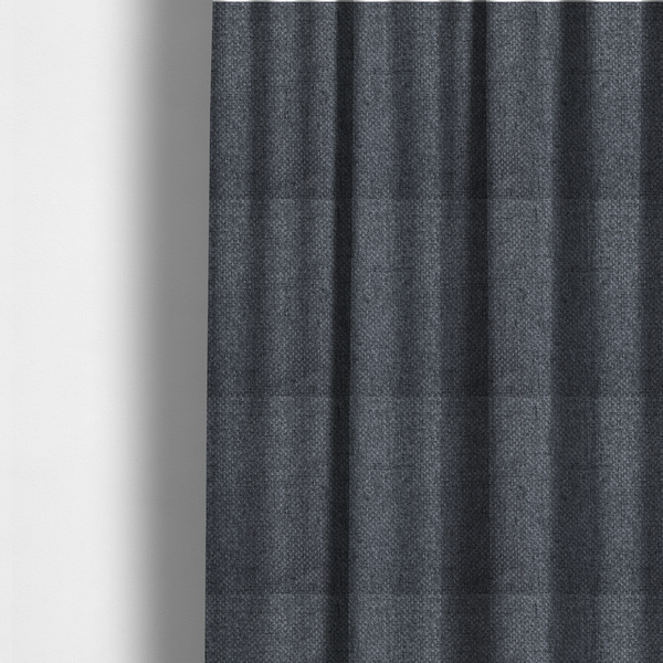 The fabric used to create these made-to-measure curtains is a  sturdy, woven upholstery fabric in a deep, sophisticated charcoal grey. Like the previous samples, it features a tight, consistent weave with an interlocking geometric pattern.