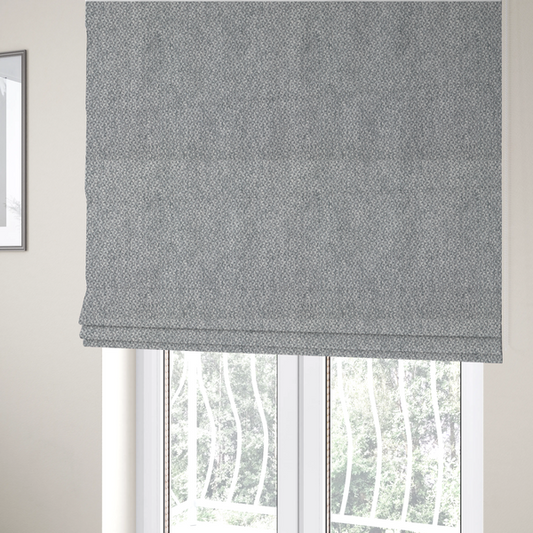 The fabric used to create these Roman blinds is a fabric features a dimensional, textured weave in a cool, soft grey.
