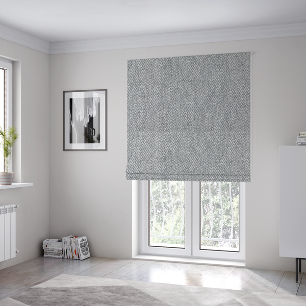 The fabric used to create these Roman blinds is a fabric features a dimensional, textured weave in a cool, soft grey.