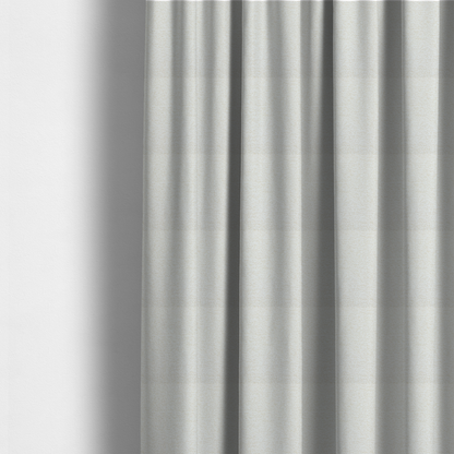 The fabric used to create these made-to-measure curtains is a  textured, off-white or cream-coloured weave. It has a bouclé-like or chunky, nubby appearance with a slightly irregular, multidimensional surface that gives it a cosy, organic, and tactile quality.