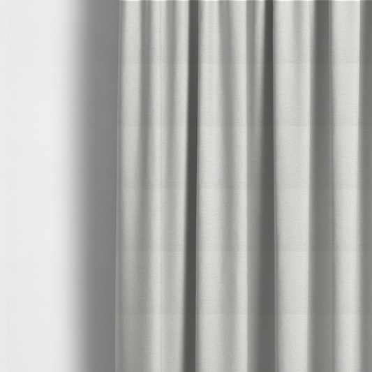 The fabric used to create these made-to-measure curtains is a  textured, off-white or cream-coloured weave. It has a bouclé-like or chunky, nubby appearance with a slightly irregular, multidimensional surface that gives it a cosy, organic, and tactile quality.