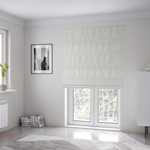 The fabric used to create these Roman blinds is a textured, off-white or cream-coloured weave. It has a bouclé-like or chunky, nubby appearance with a slightly irregular, multidimensional surface that gives it a cosy, organic, and tactile quality.