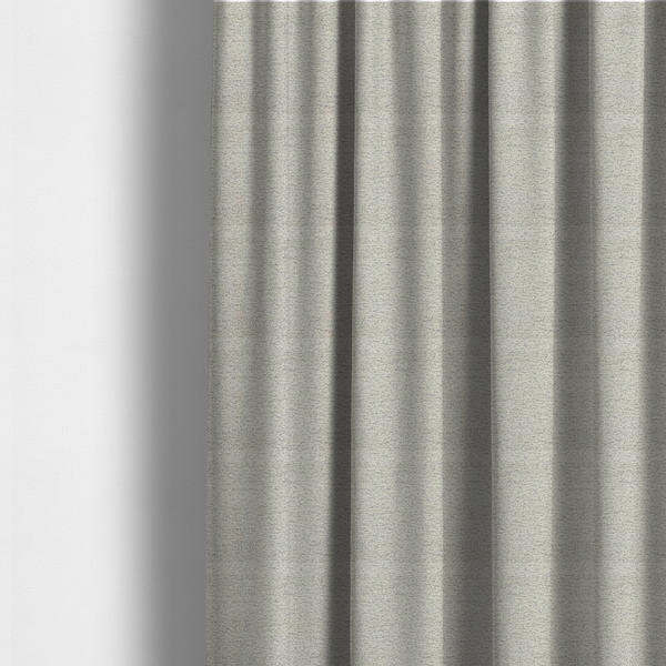 The fabric used to create these made-to-measure curtains is a sophisticated, two-tone textured weave that blends cool grey and soft cream yarns.
