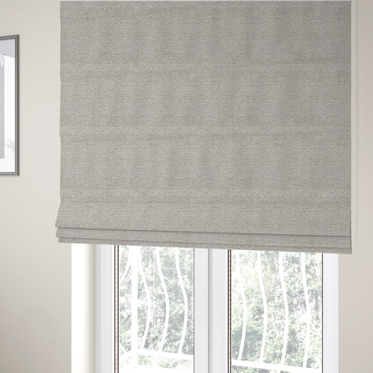 The fabric used to create these Roman blinds is a sophisticated, two-tone textured weave that blends cool grey and soft cream yarns.