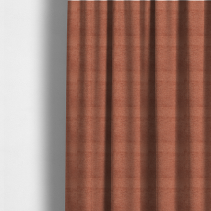 The fabric used to create these made-to-measure curtains is a vibrant, warm terracotta or rust-coloured weave. It features a dense, structured texture with horizontal ribbing and a consistent, slightly nubby finish that adds depth and character.