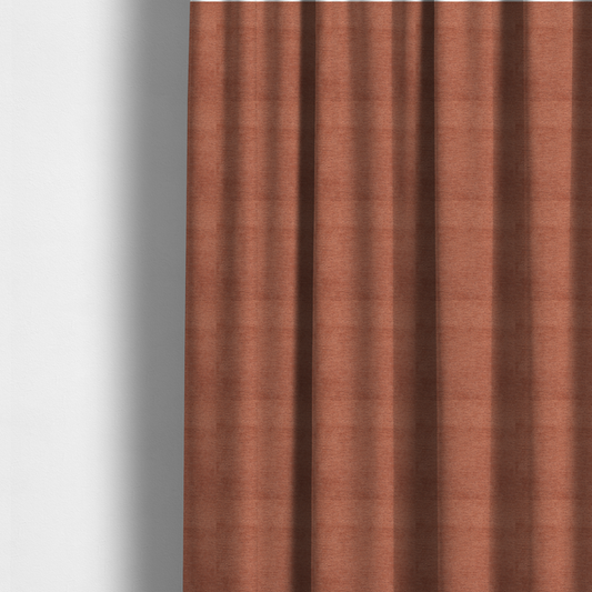 The fabric used to create these made-to-measure curtains is a vibrant, warm terracotta or rust-coloured weave. It features a dense, structured texture with horizontal ribbing and a consistent, slightly nubby finish that adds depth and character.