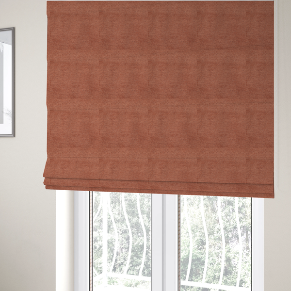 The fabric used to create these Roman blinds is a  vibrant, warm terracotta or rust-coloured weave. It features a dense, structured texture with horizontal ribbing and a consistent, slightly nubby finish that adds depth and character.