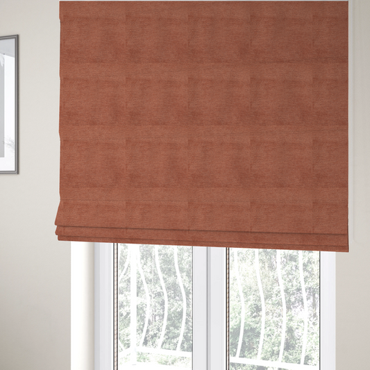The fabric used to create these Roman blinds is a  vibrant, warm terracotta or rust-coloured weave. It features a dense, structured texture with horizontal ribbing and a consistent, slightly nubby finish that adds depth and character.
