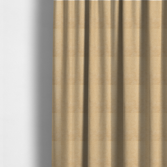 The fabric used to create these made-to-measure curtains is a warm, golden-beige weave with a sophisticated, textured finish. It is crafted with a dense, nubby construction that creates a subtle horizontal ribbing effect, providing both visual depth and a tactile, inviting feel.
