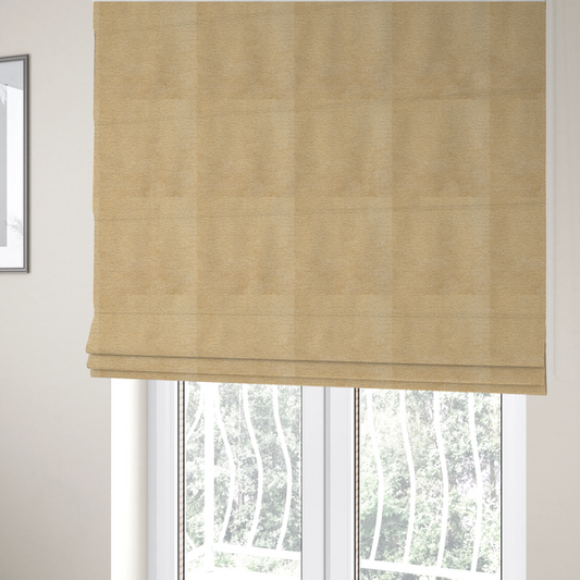 The fabric used to create these Roman blinds is a warm, golden-beige weave with a sophisticated, textured finish. It is crafted with a dense, nubby construction that creates a subtle horizontal ribbing effect, providing both visual depth and a tactile, inviting feel.