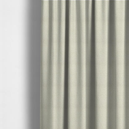 The fabric used to create these made-to-measure curtains is a light, creamy ivory weave with a refined, textured appearance. It is crafted with a dense, nubby construction that creates a subtle horizontal ribbing effect, providing both visual dimension and a soft, tactile quality.