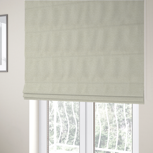 The fabric used to create these Roman blinds is a light, creamy ivory weave with a refined, textured appearance. It is crafted with a dense, nubby construction that creates a subtle horizontal ribbing effect, providing both visual dimension and a soft, tactile quality.