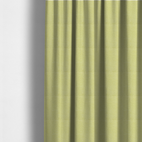 The fabric used to create these made-to-measure curtains is a fresh, vibrant chartreuse-green weave with a sophisticated, textured finish. It is crafted with a dense, nubby construction that creates a subtle horizontal ribbing effect, providing both visual dimension and a soft, inviting tactile quality.