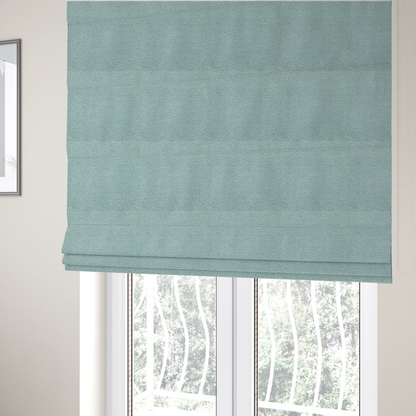The fabric used to create these Roman blinds is a serene, cool-toned seafoam or soft teal weave with a sophisticated, textured finish.