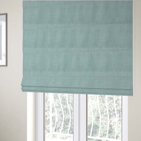 The fabric used to create these Roman blinds is a serene, cool-toned seafoam or soft teal weave with a sophisticated, textured finish.