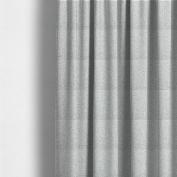 The fabric used to create these made-to-measure curtains is a clean, contemporary light-grey and white weave. It is crafted with a dense, nubby construction that creates a subtle horizontal ribbing effect, providing both visual dimension and a soft, tactile quality.