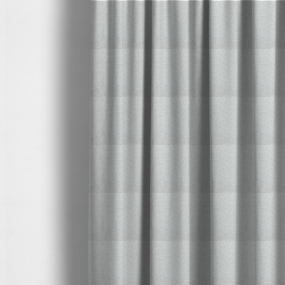 The fabric used to create these made-to-measure curtains is a clean, contemporary light-grey and white weave. It is crafted with a dense, nubby construction that creates a subtle horizontal ribbing effect, providing both visual dimension and a soft, tactile quality.